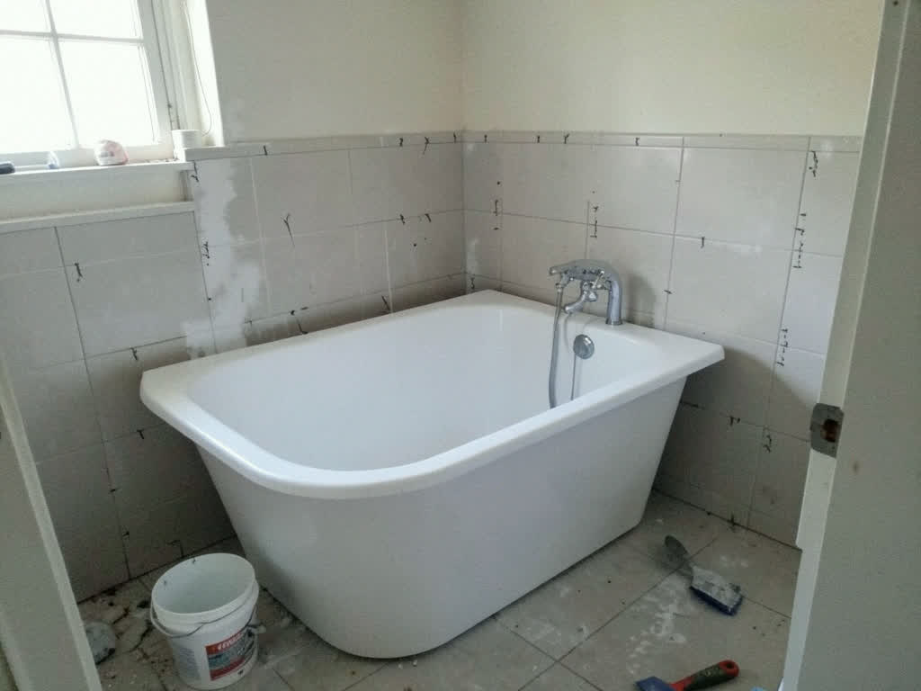 A freestanding tub mid-remodel with tile in progress